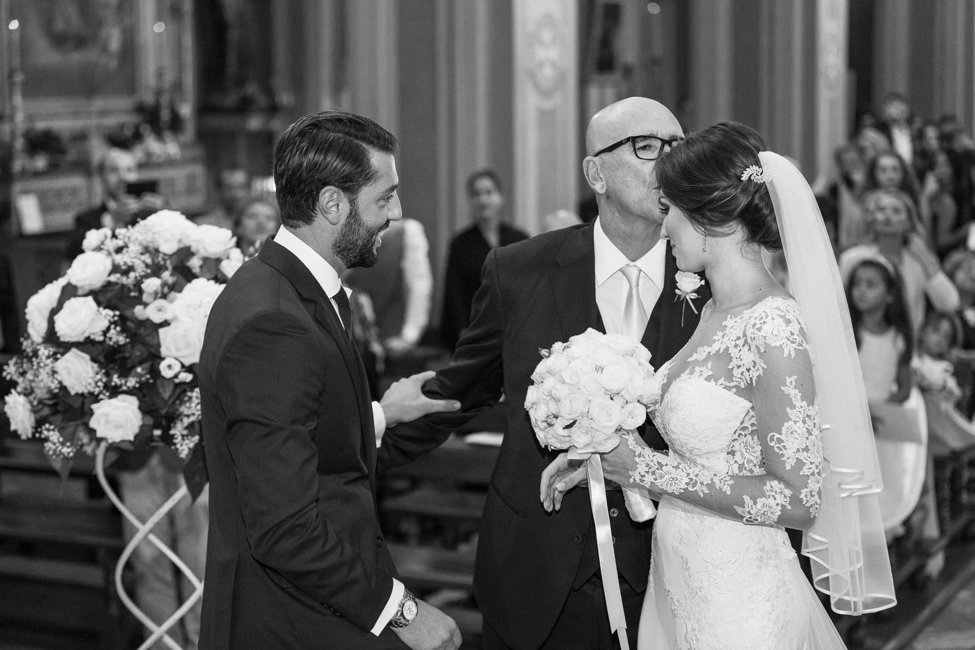 In bianco e nero, il papà bacia la sposa prima di lasciarla