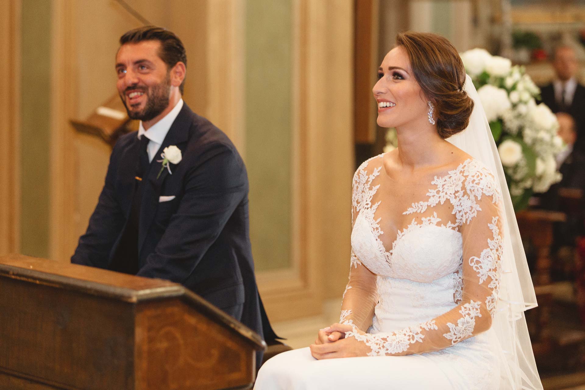 Gli sposi si sorridono, seduti all'altare