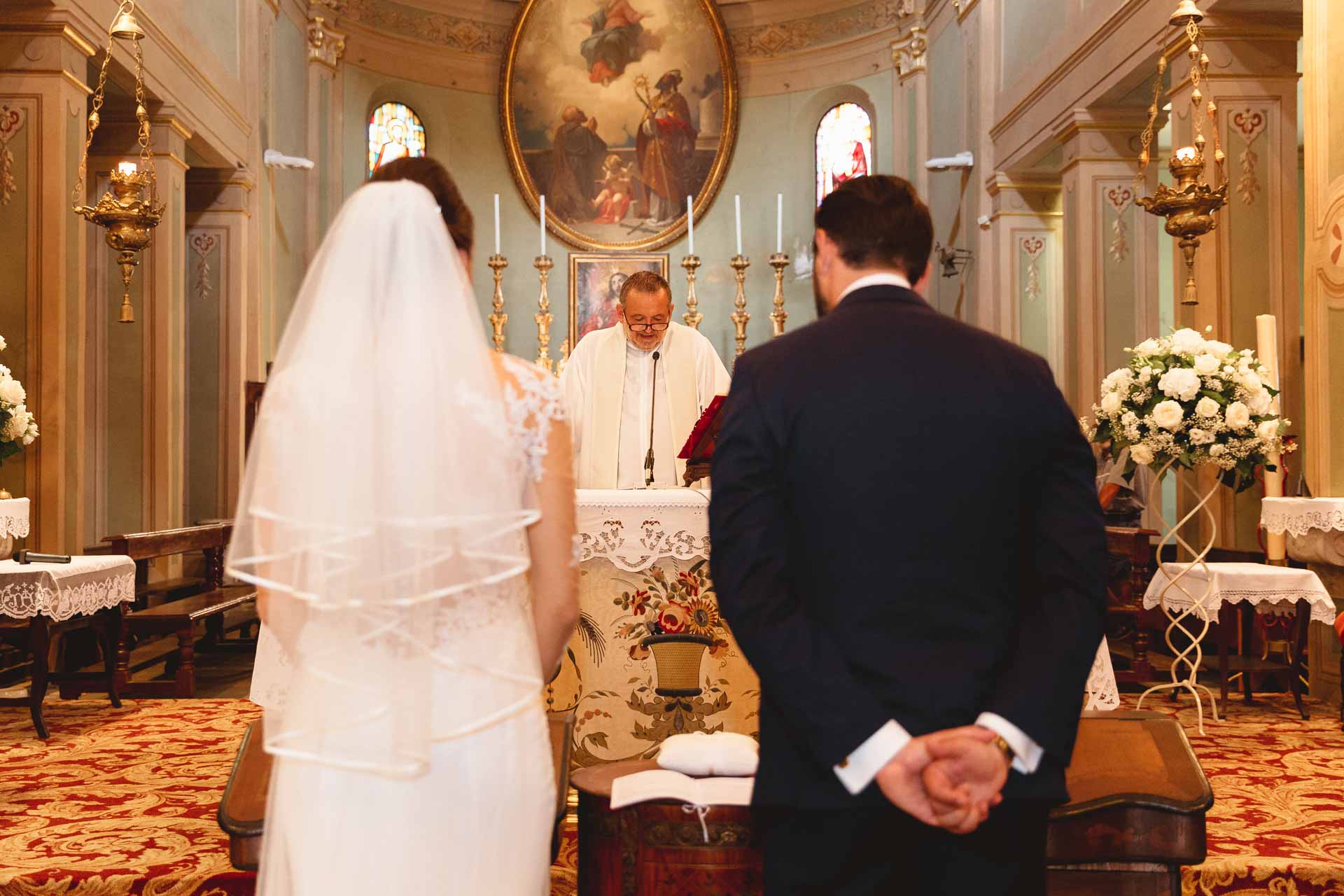 Gli sposi all'altare davanti al sacerdote, la sposa con il velo