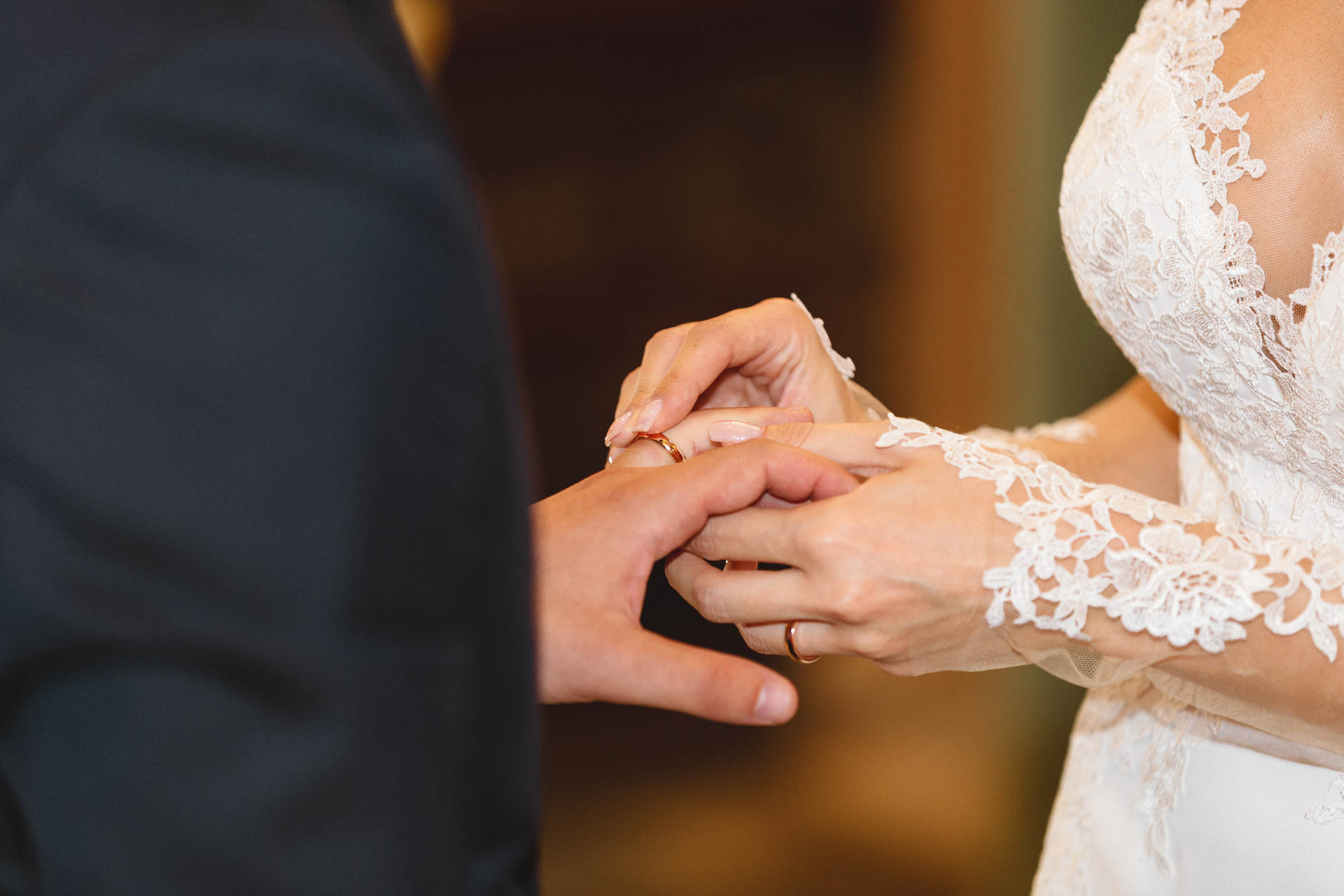 La sposa infila la fede allo sposo, da vicino