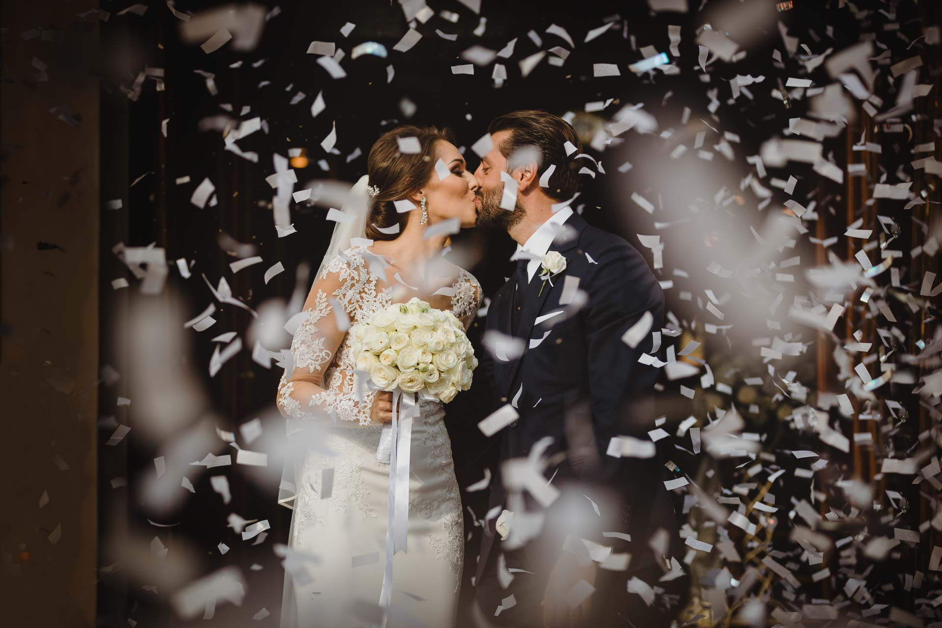 Il bacio degli sposi tra i coriandoli bianchi