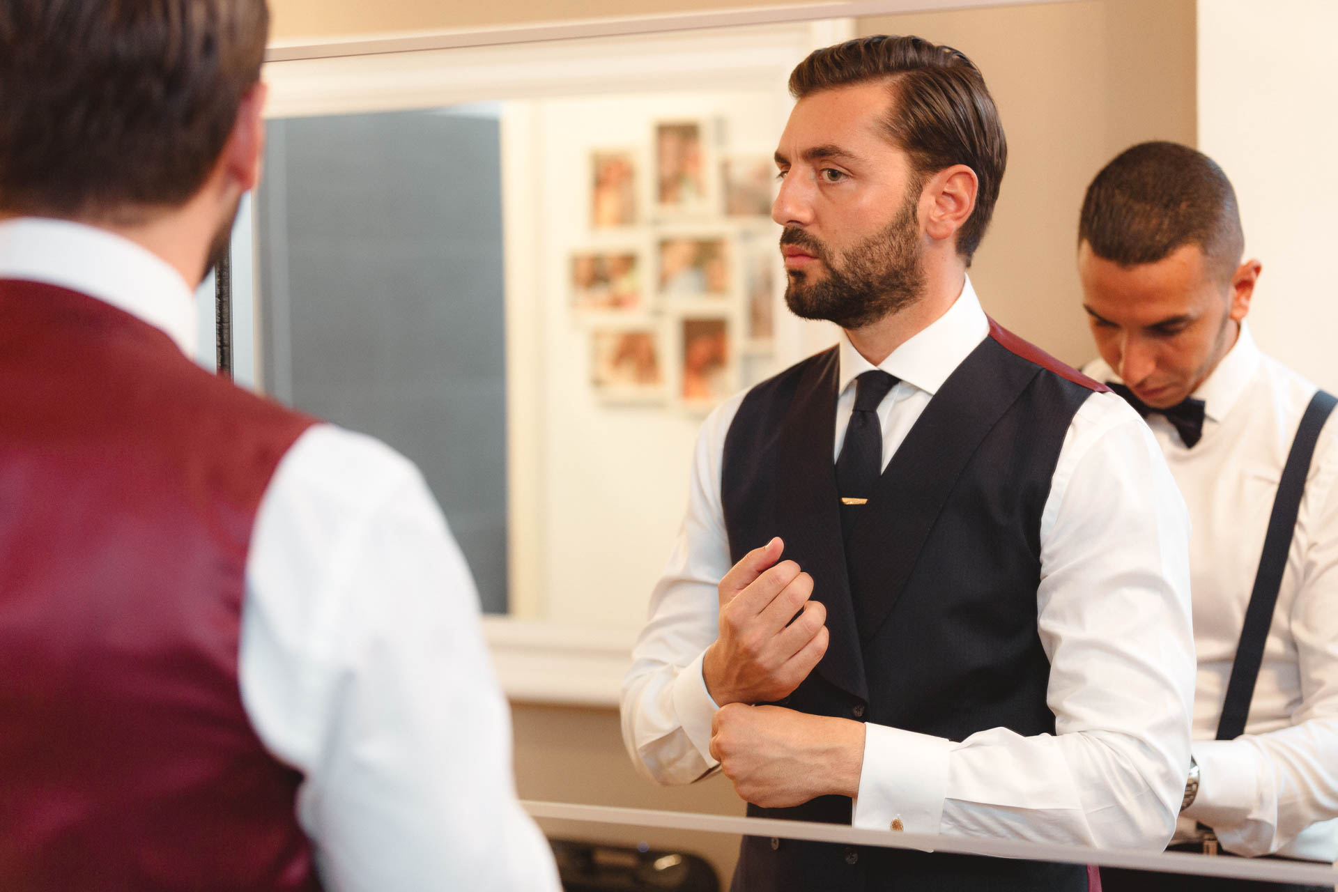 Lo sposo in gilet si sistema i polsini, con l'amico accanto