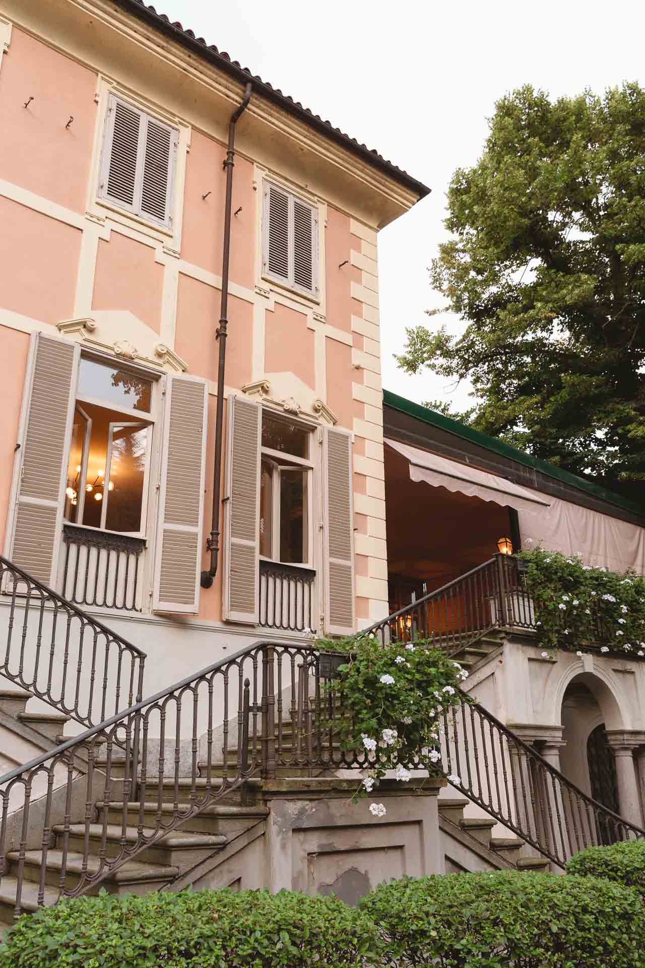 La facciata rosa di Villa Sassi, con la scala e le persiane