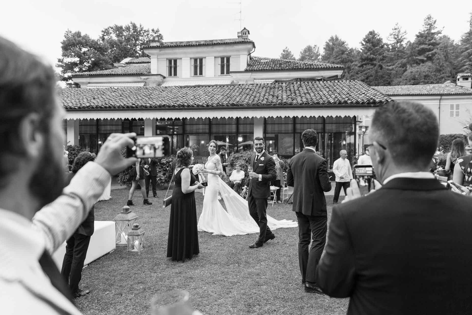 In bianco e nero, gli sposi sul prato di Villa Sassi tra gli invitati