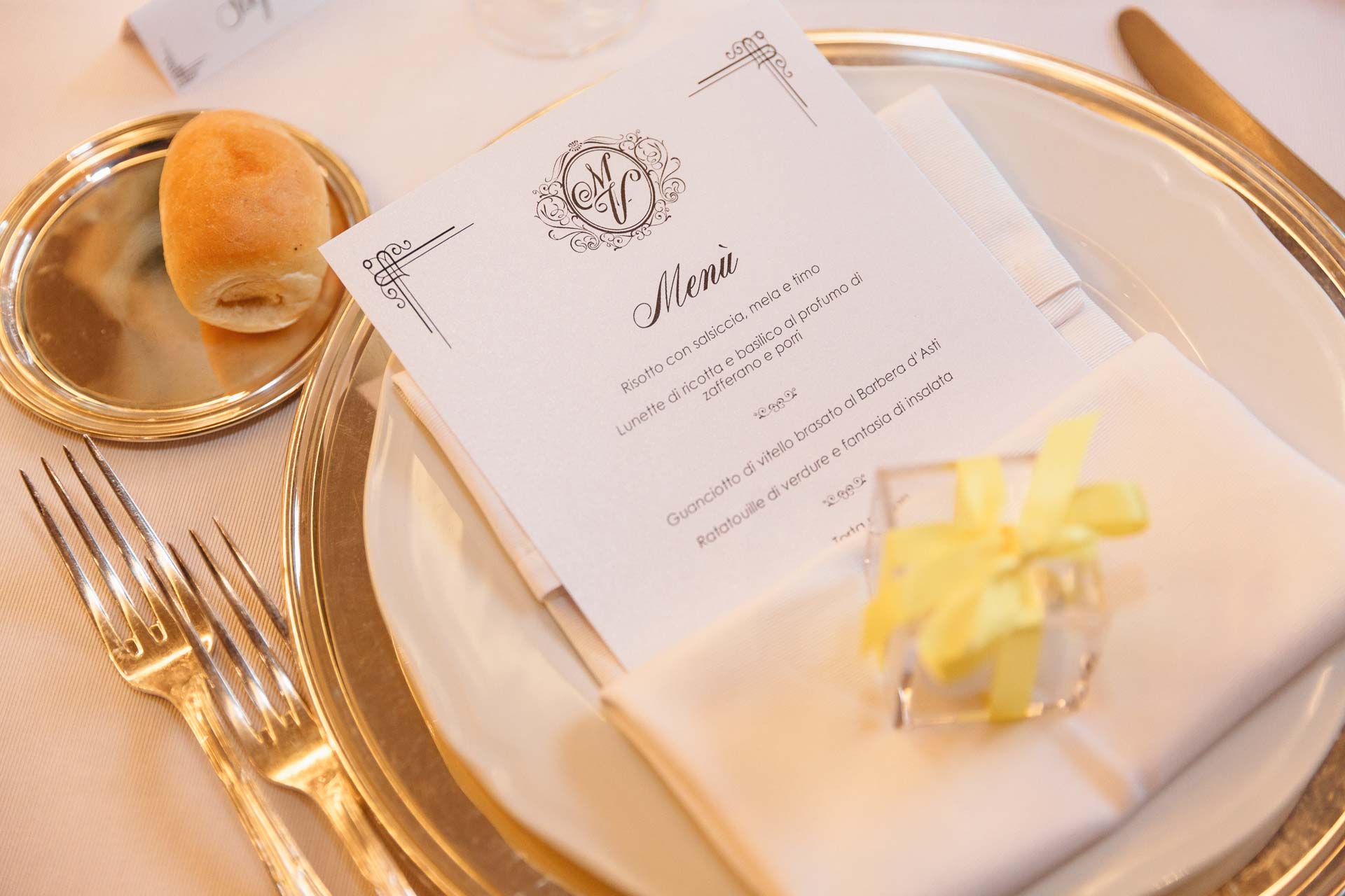 Il menu con le iniziali degli sposi, sul sottopiatto dorato