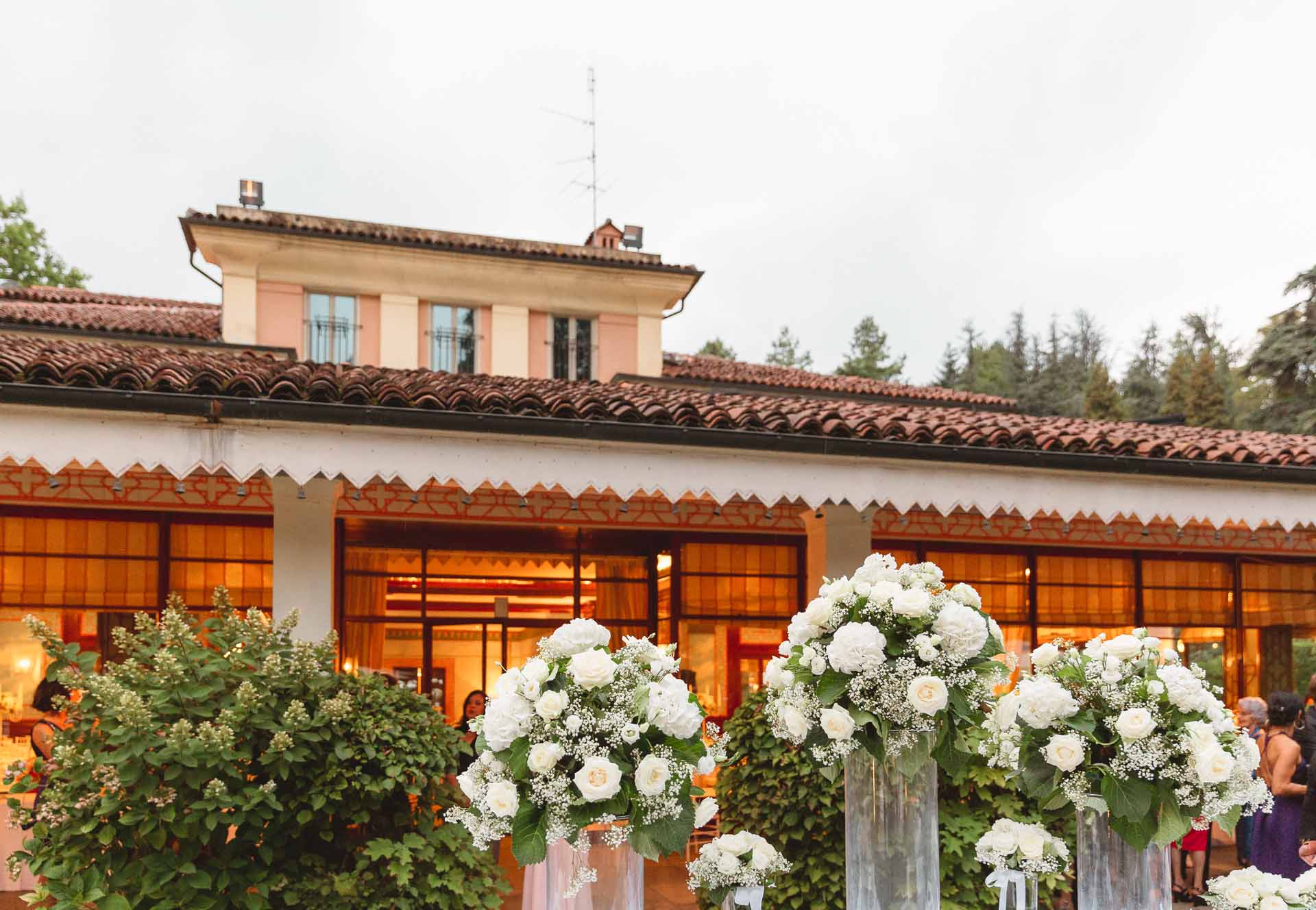 Villa Sassi illuminata dietro le composizioni di fiori bianchi
