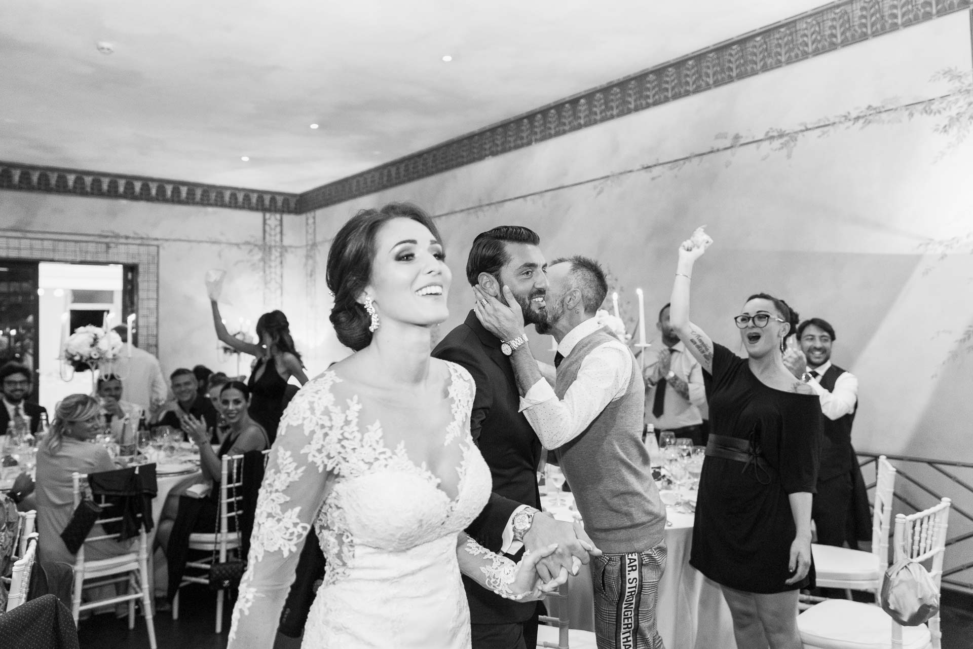 In bianco e nero, la sposa ride tra gli amici che cantano