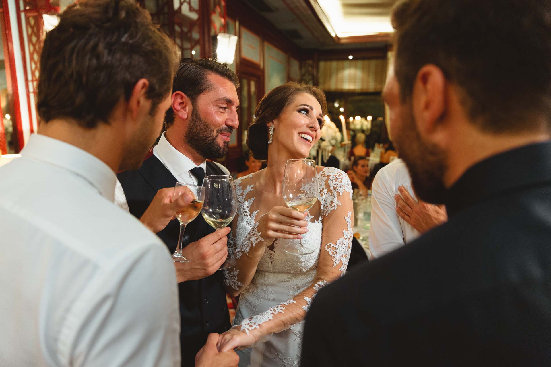 La sposa brinda ridendo con lo sposo e gli amici