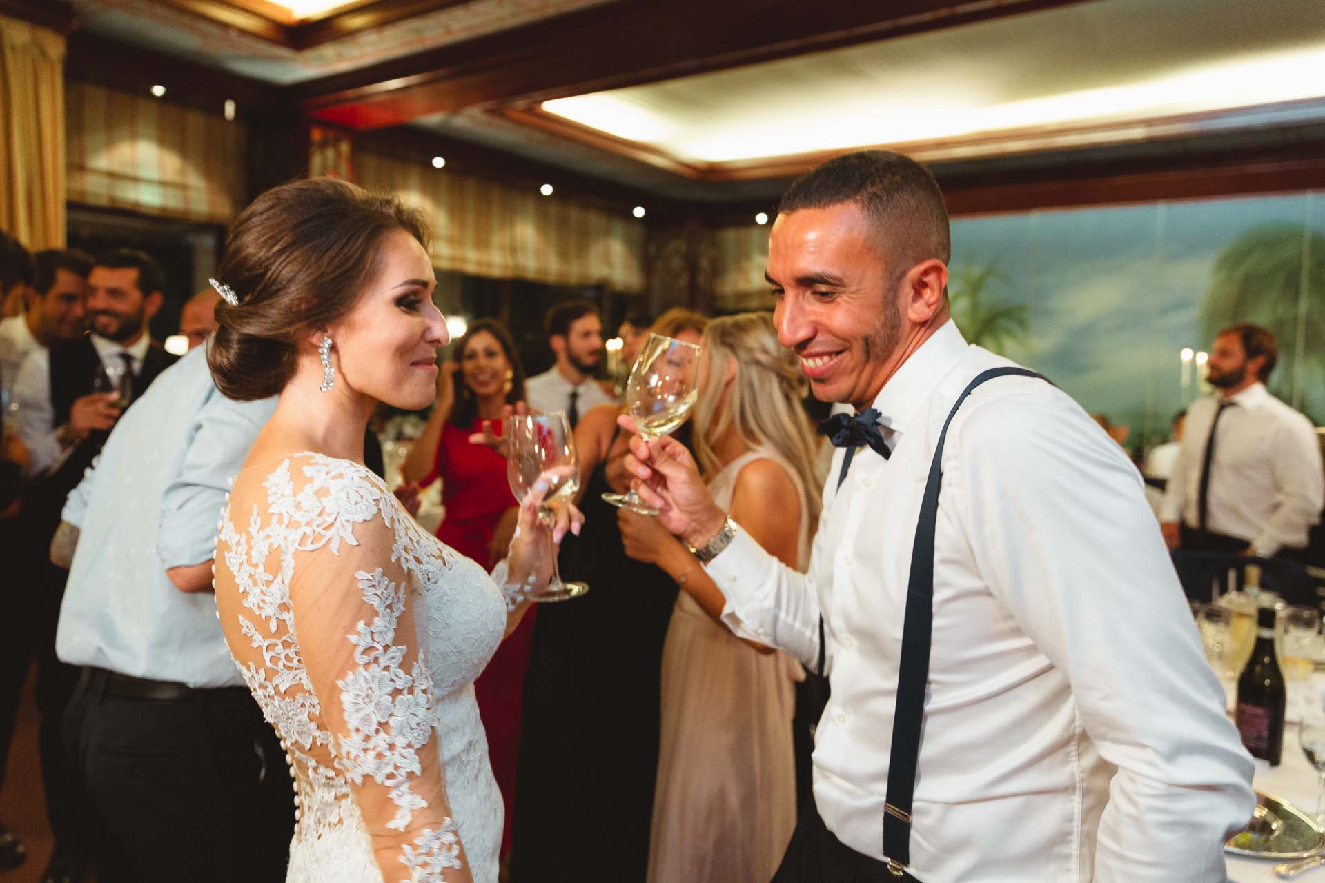 La sposa brinda con l'amico in papillon e bretelle