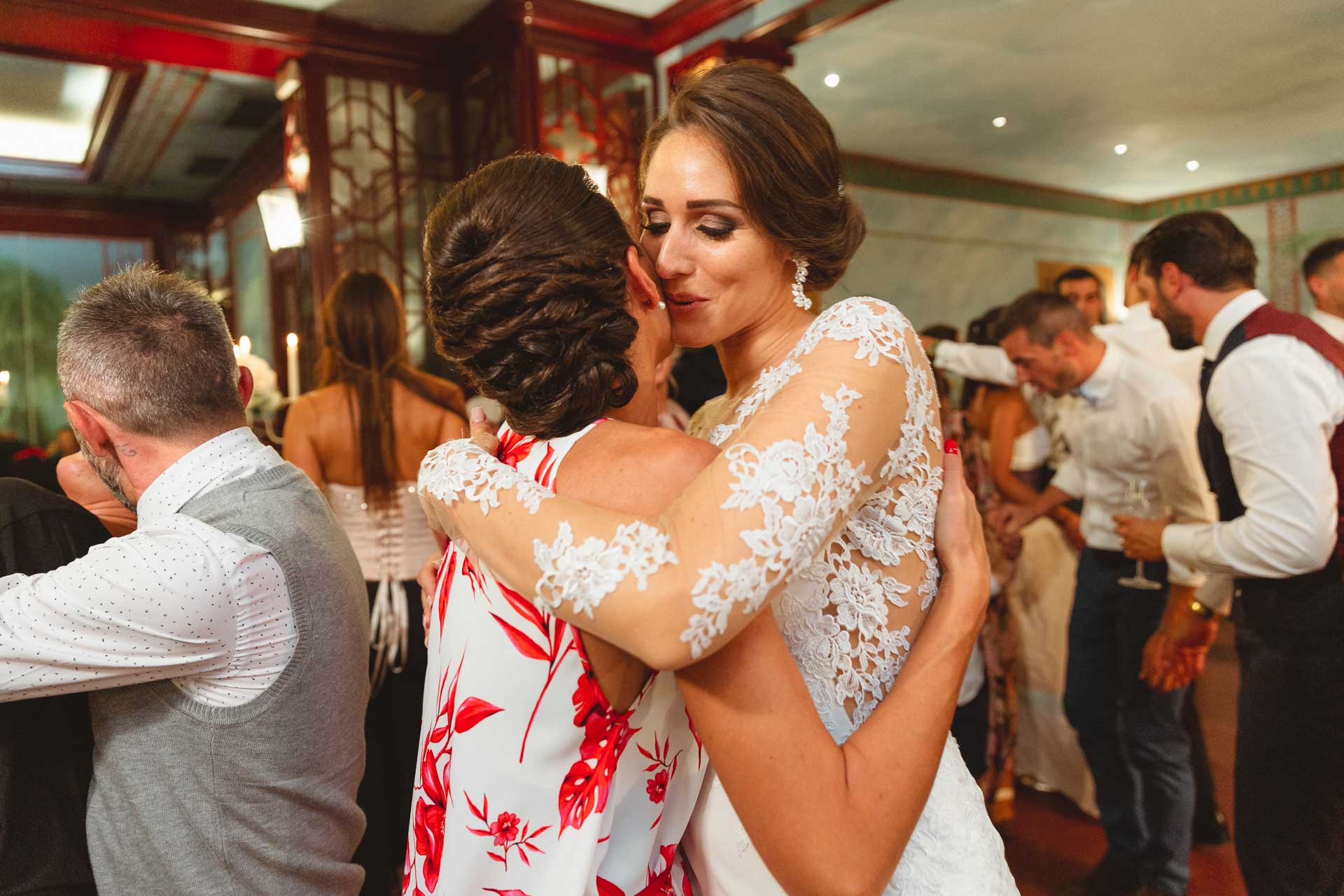 La sposa abbraccia l'amica in abito a fiori