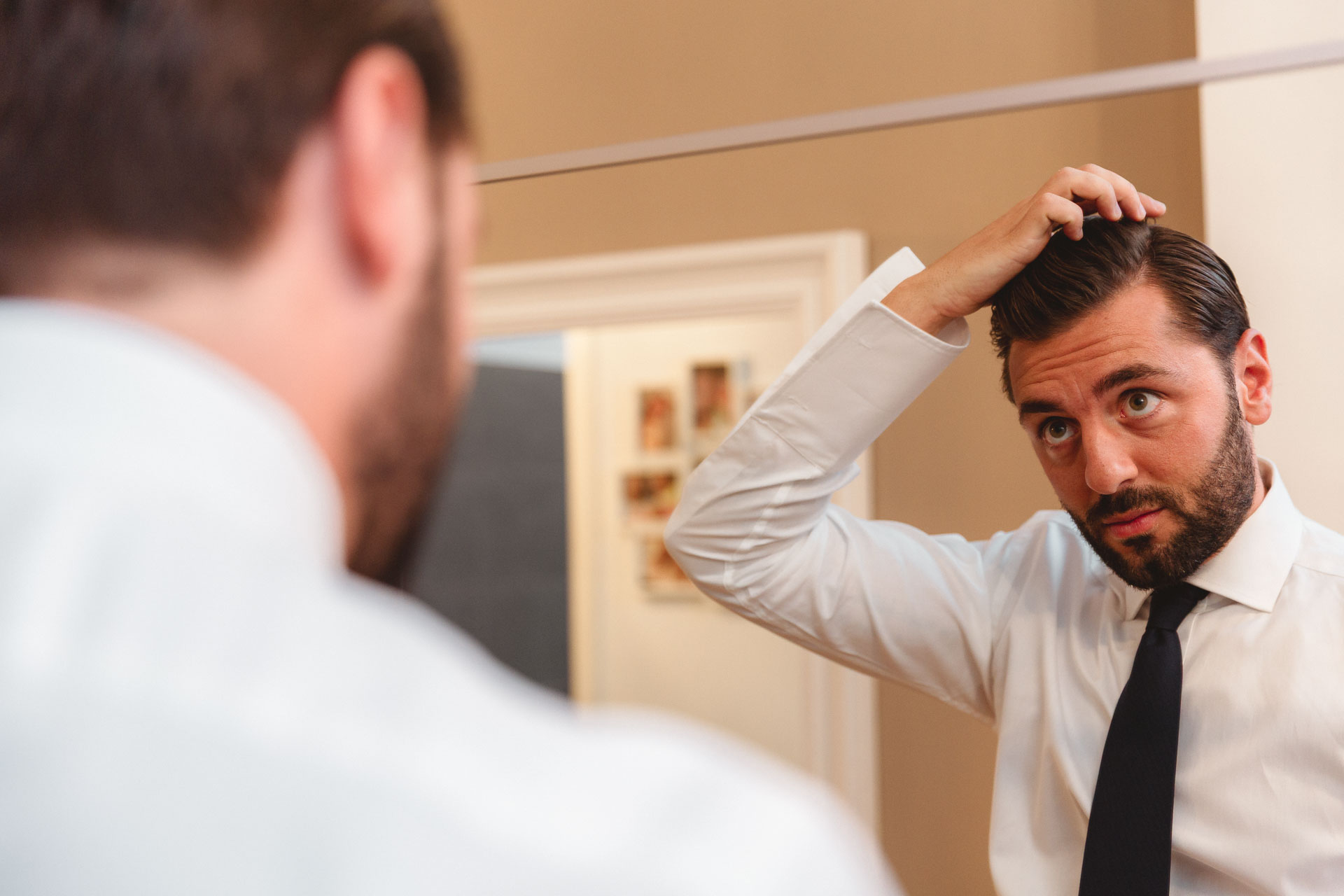Lo sposo si sistema i capelli allo specchio