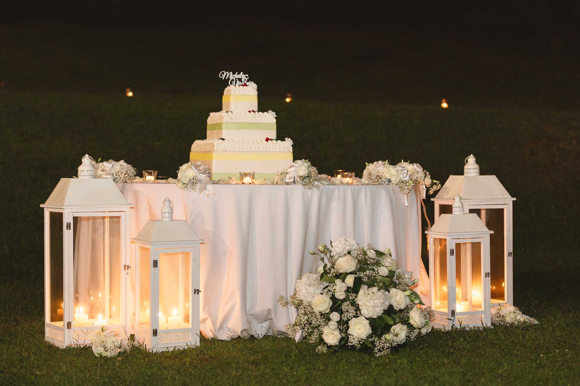 La torta nuziale sul prato, tra le lanterne bianche