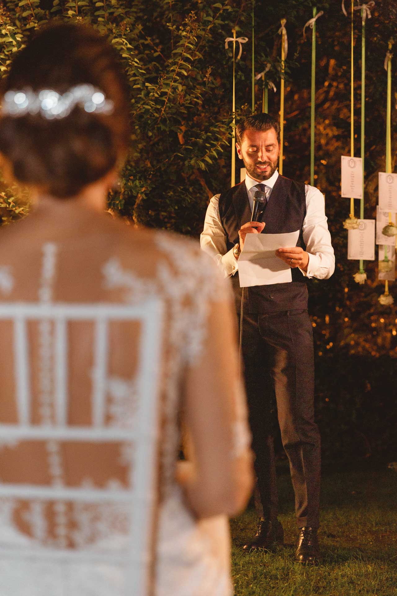 Lo sposo legge una lettera alla sposa nel parco di Villa Sassi, di sera