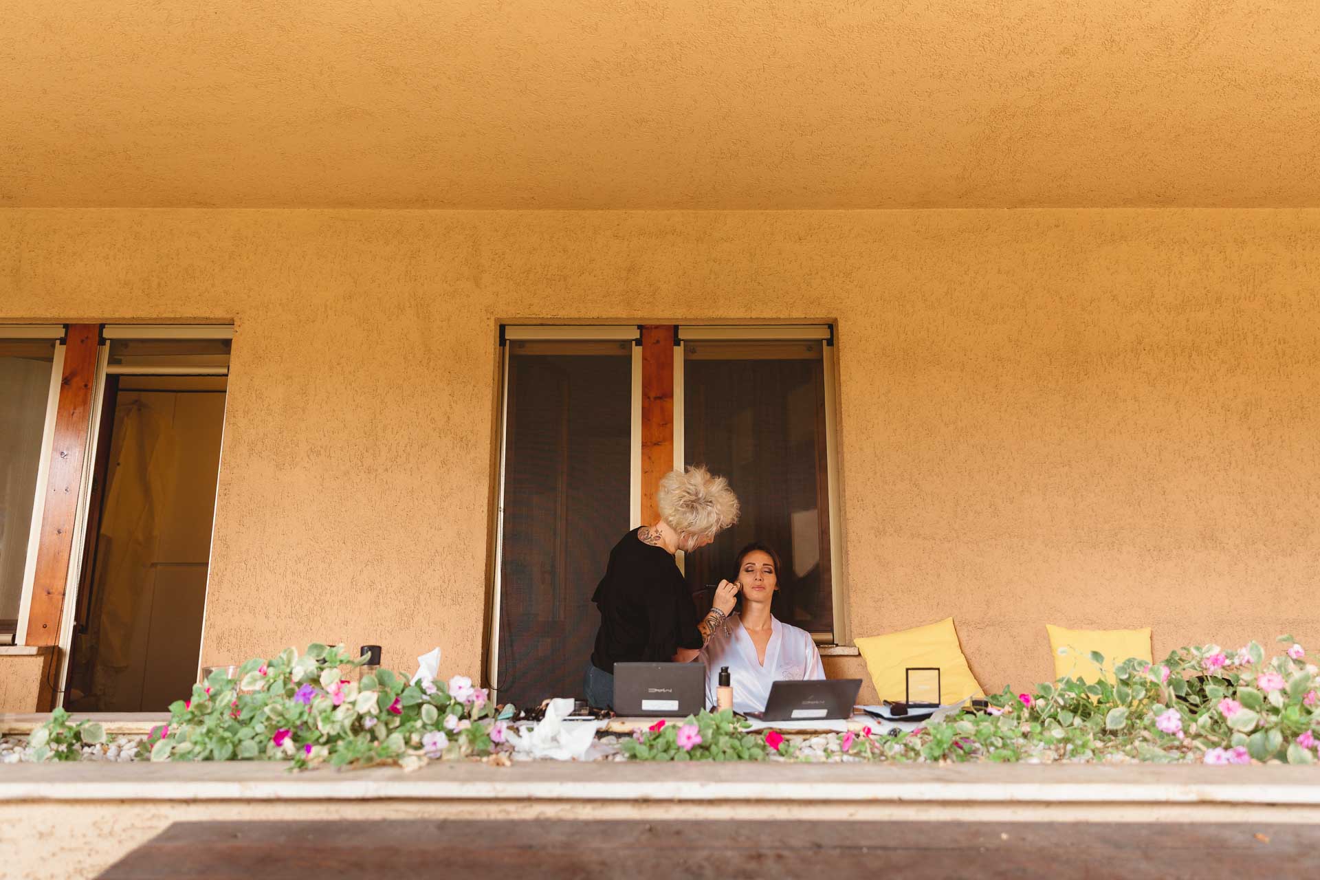 La sposa al trucco sul balcone fiorito