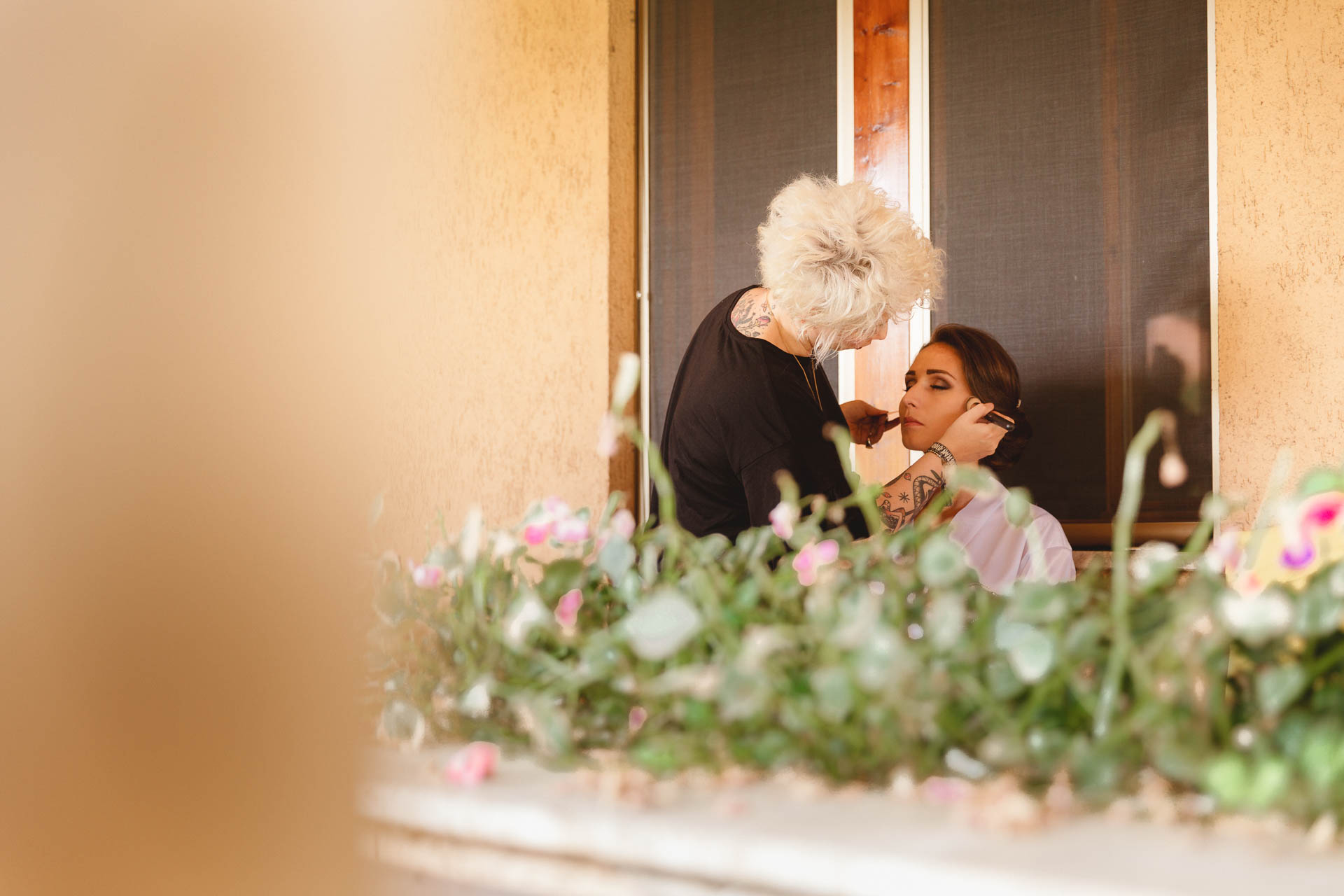 La truccatrice al lavoro sul balcone, tra i fiori