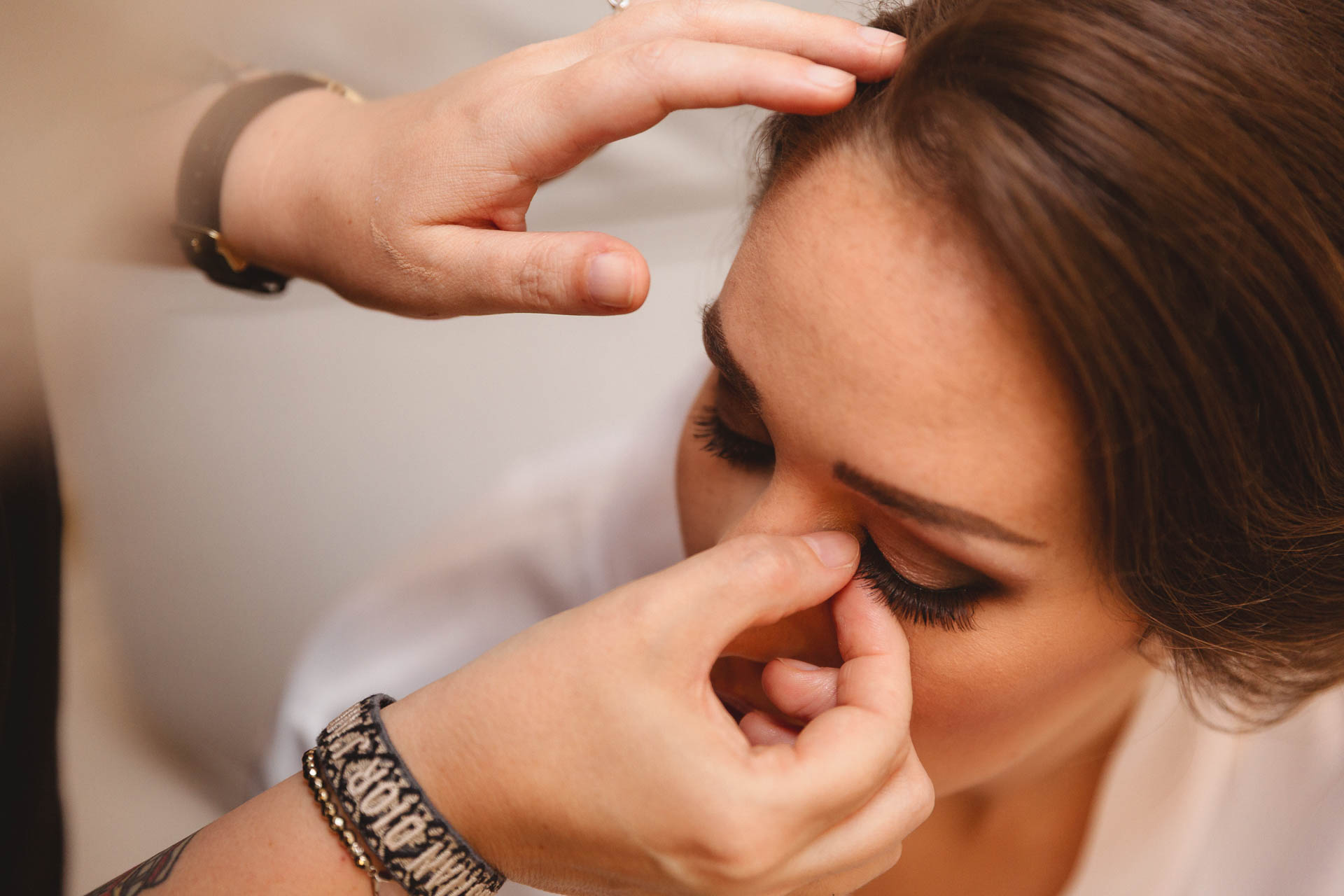 La truccatrice applica le ciglia alla sposa