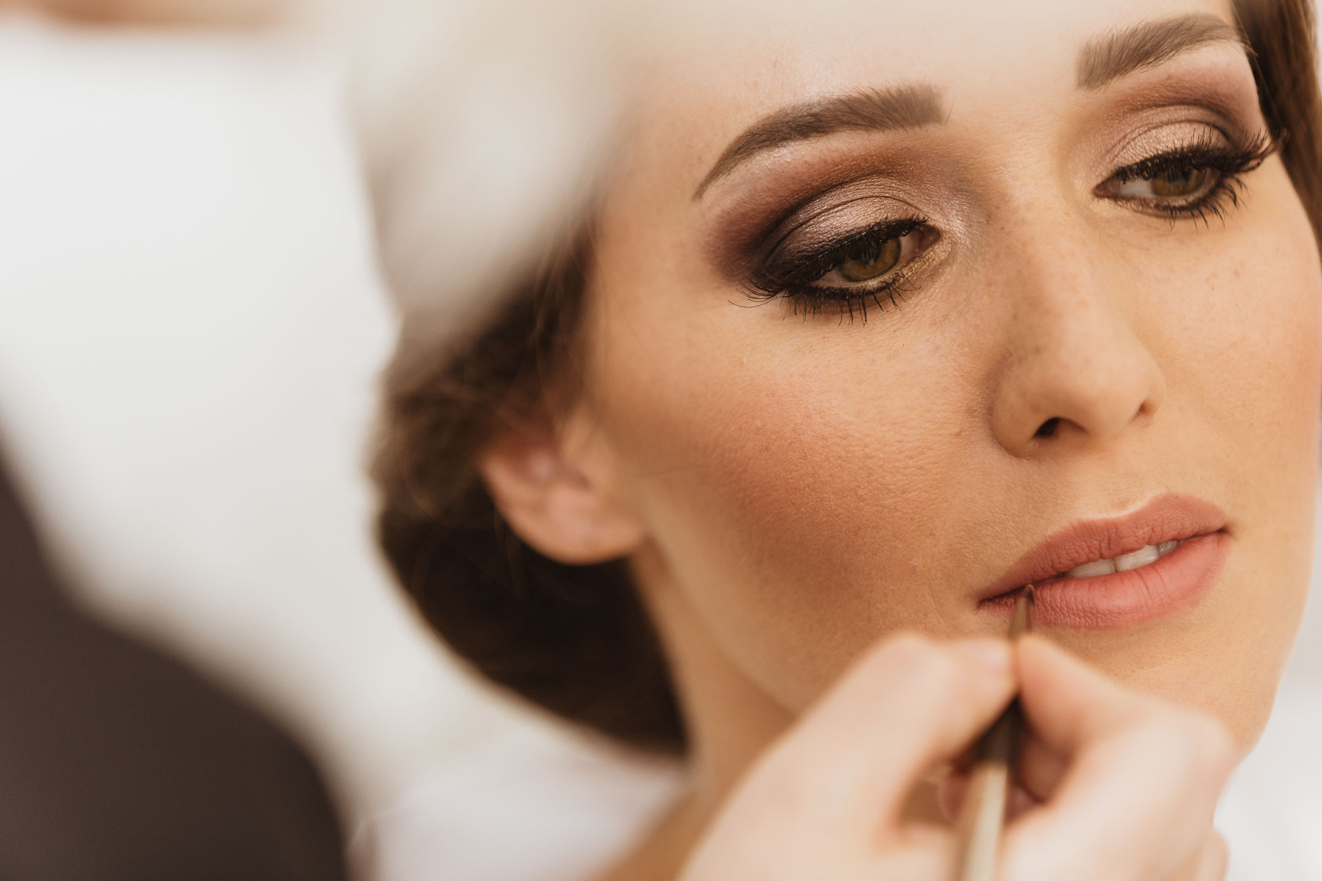 La sposa abbassa lo sguardo durante il trucco