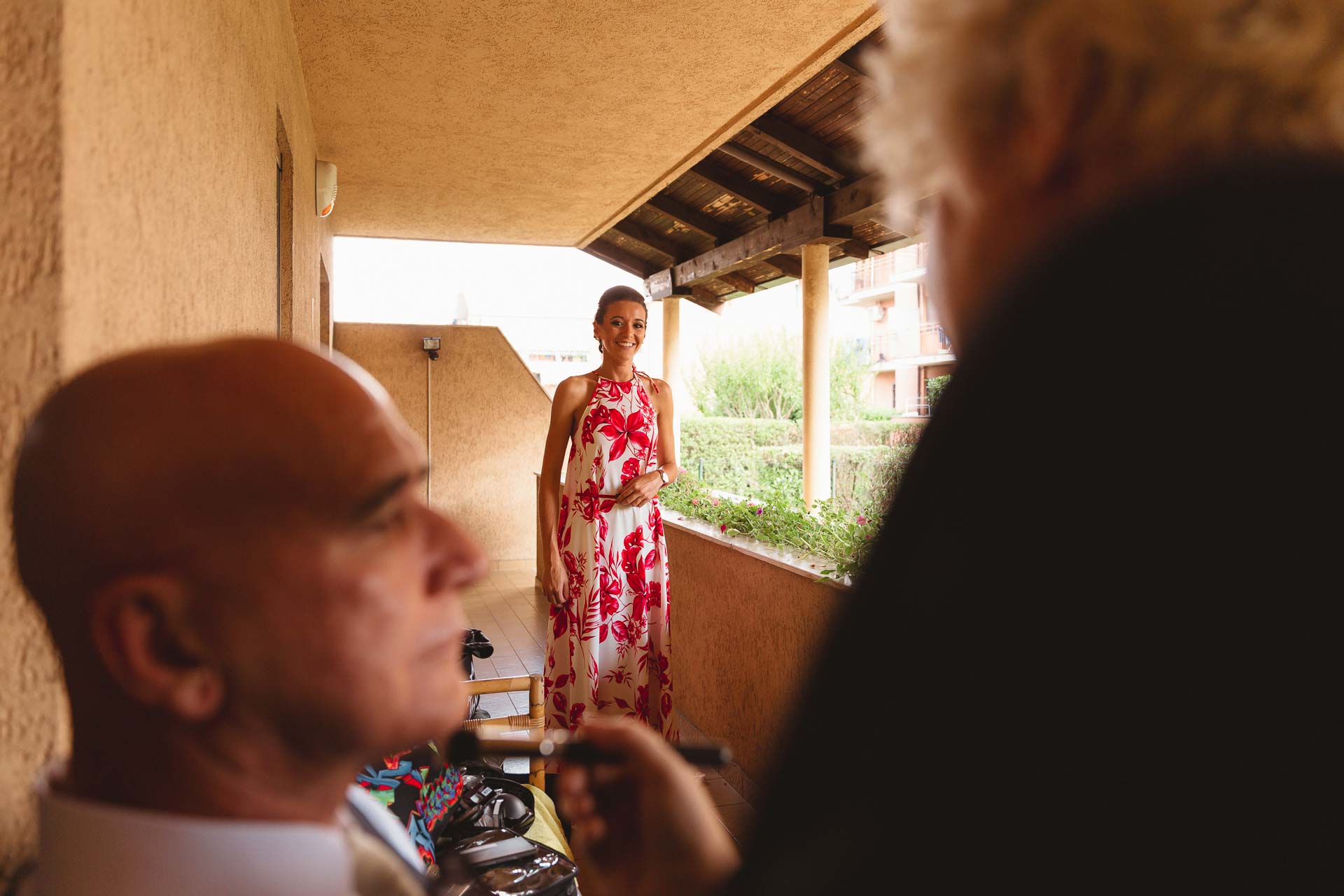 Un signore sul balcone e l'amica in abito a fiori