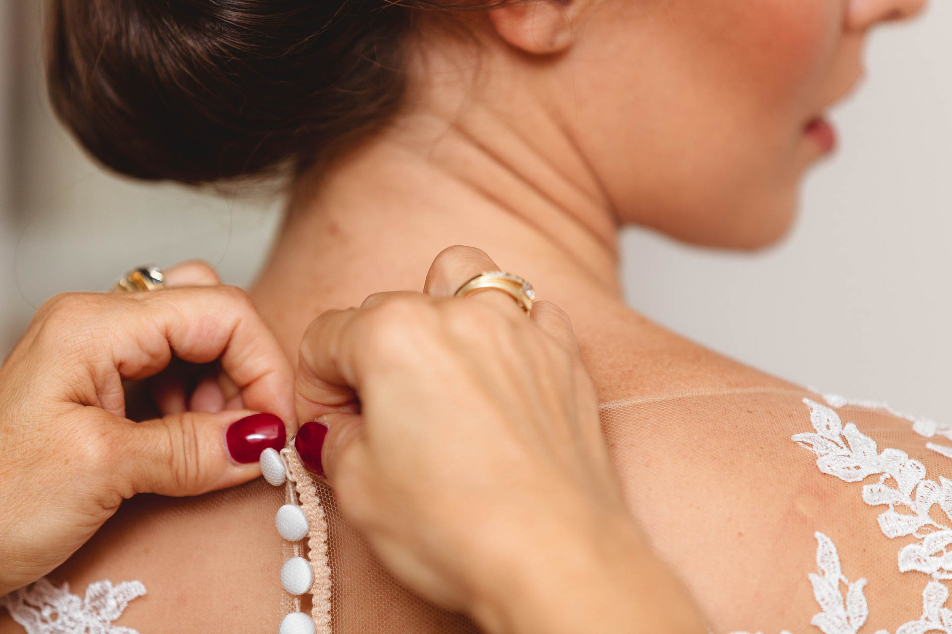 Le mani della mamma sui bottoni dell'abito