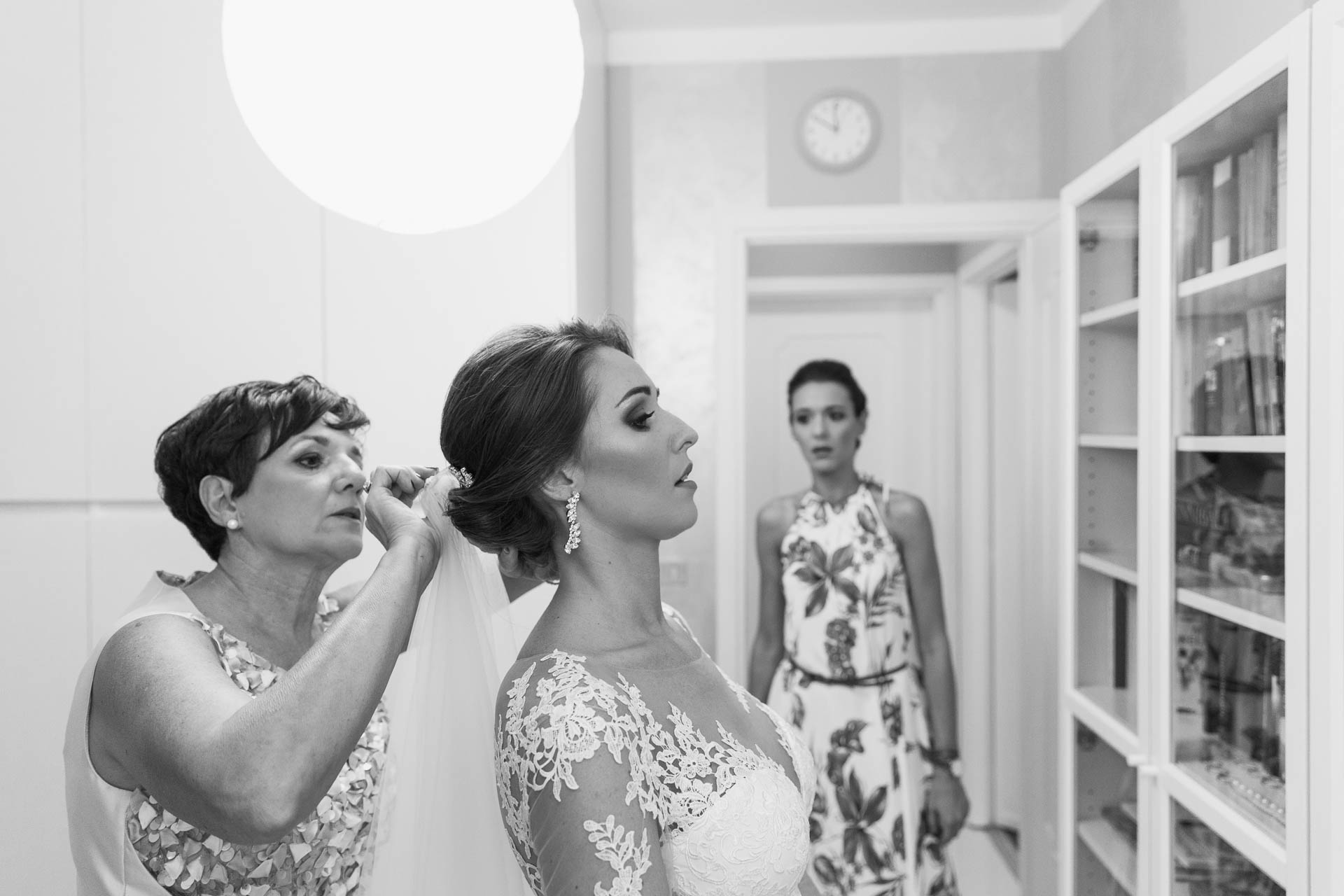 In bianco e nero, la mamma sistema il velo della sposa