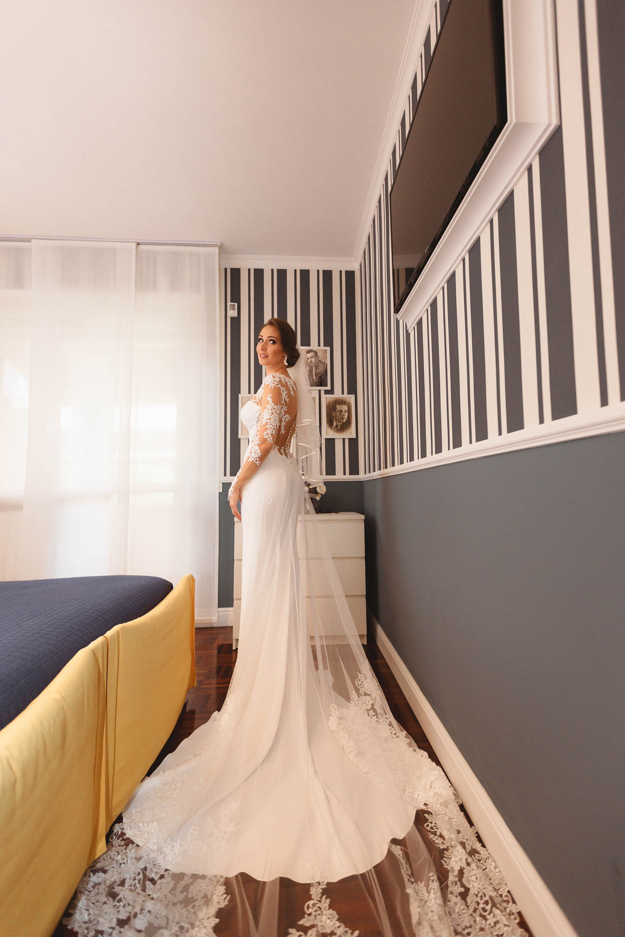 La sposa in piedi nella camera, con lo strascico sul pavimento