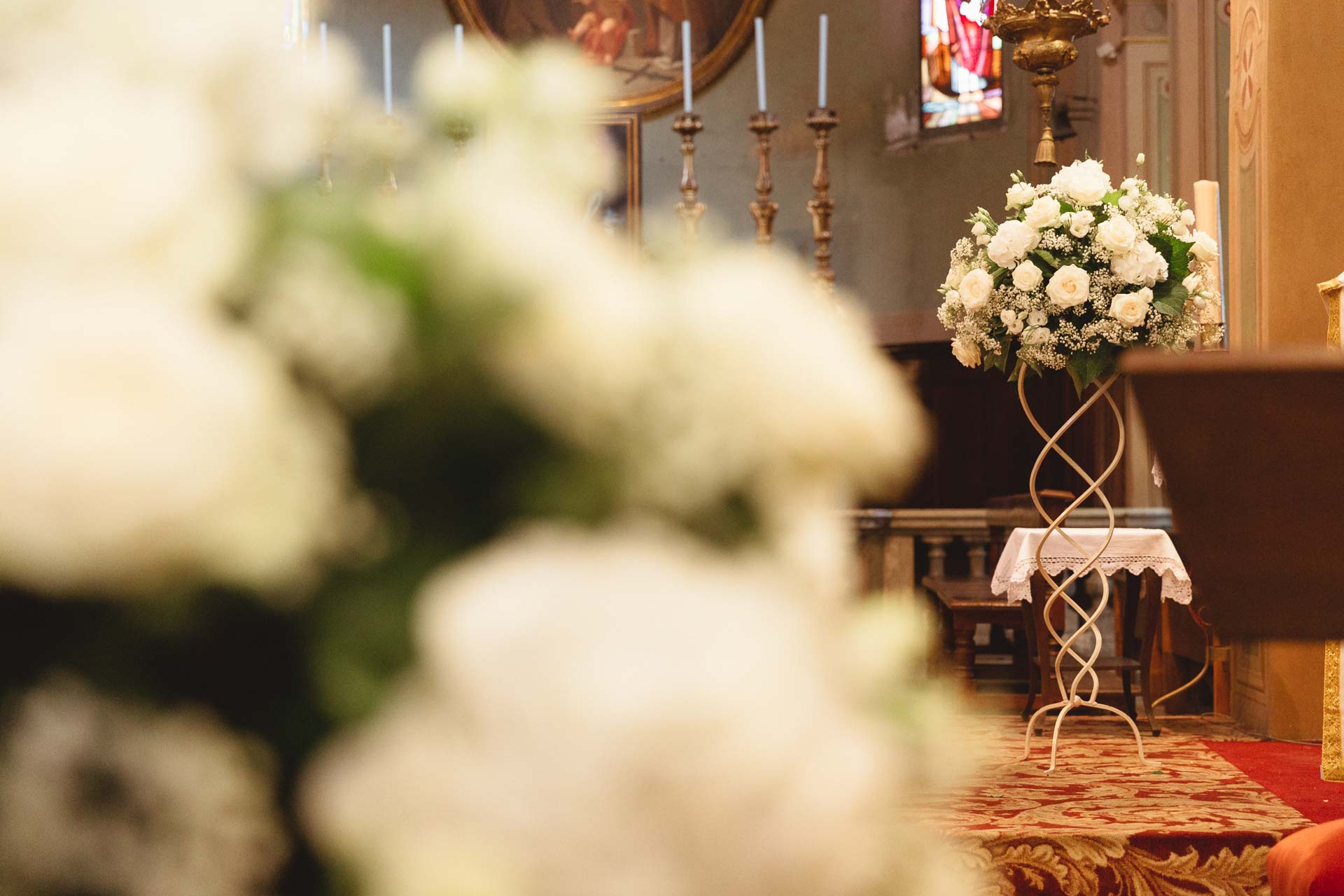 I fiori bianchi in primo piano, con l'altare sullo sfondo