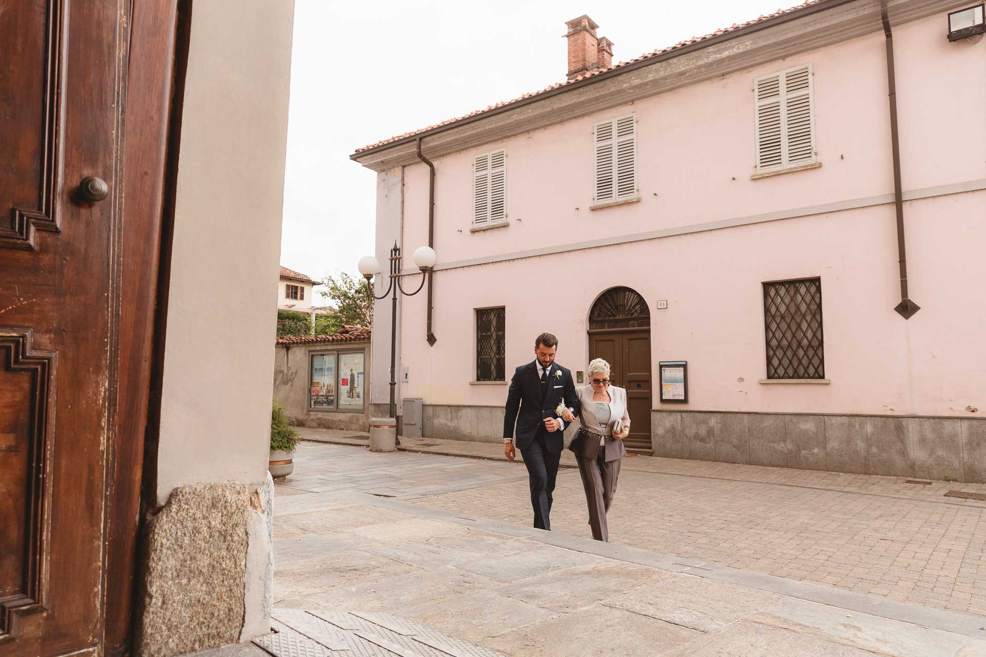 Lo sposo e la mamma arrivano in chiesa, visti dal portone