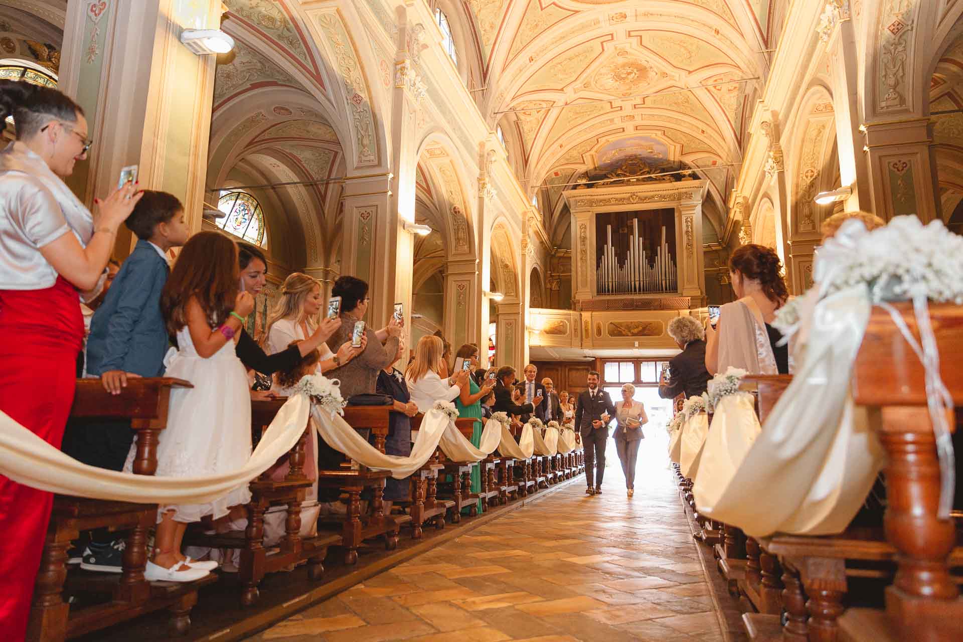 Gli invitati in piedi lungo la navata, verso l'organo
