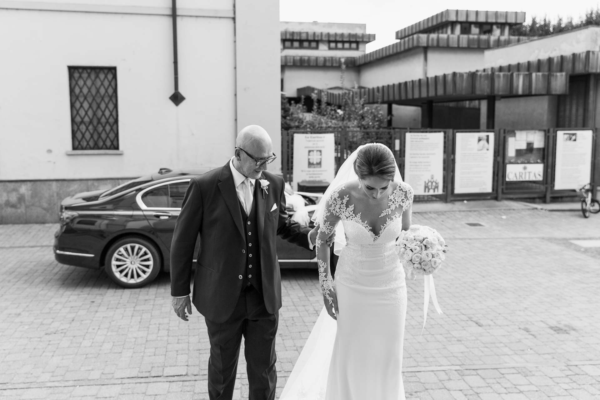 In bianco e nero, la sposa e il papà verso la chiesa