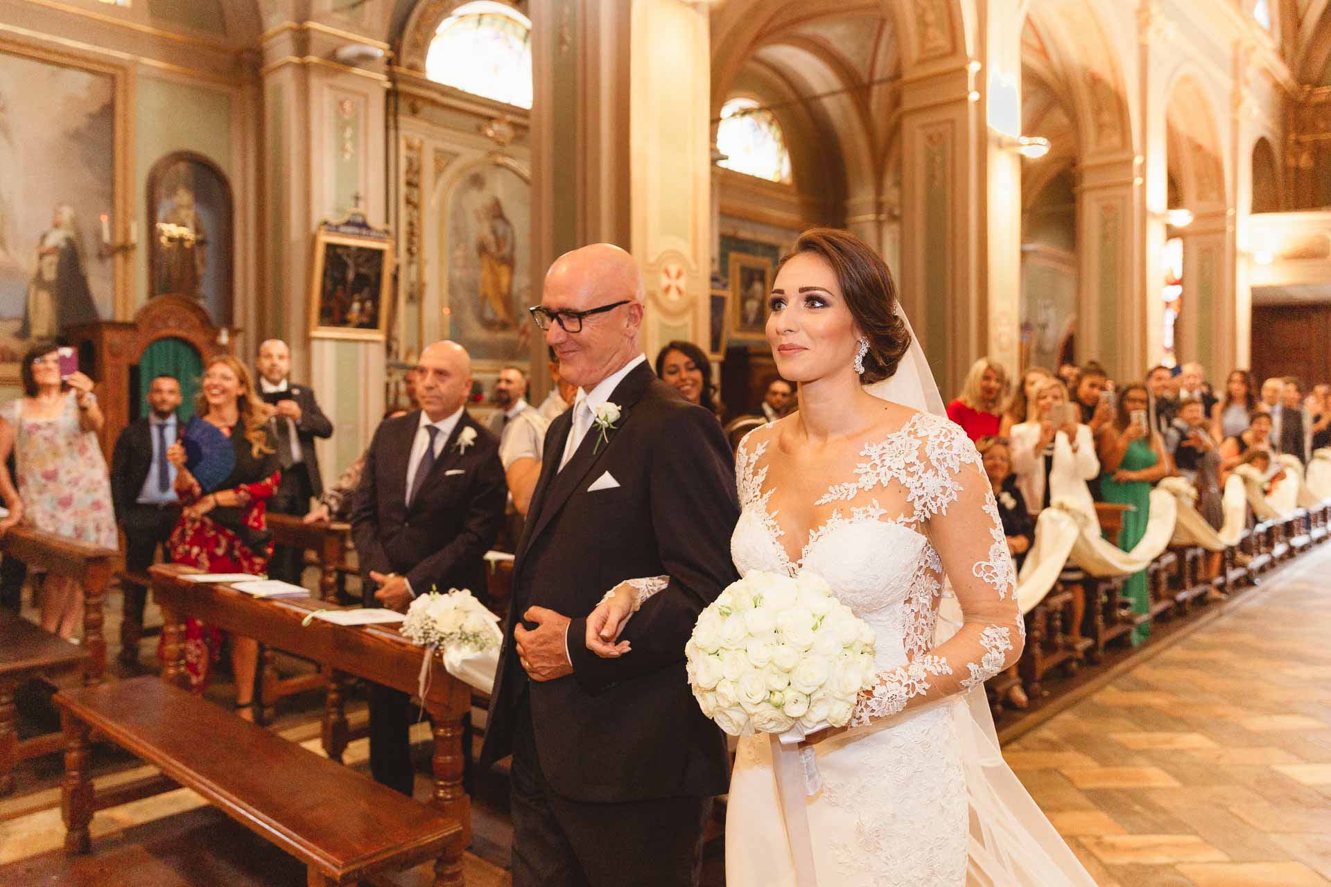 La sposa e il papà lungo la navata, tra gli invitati